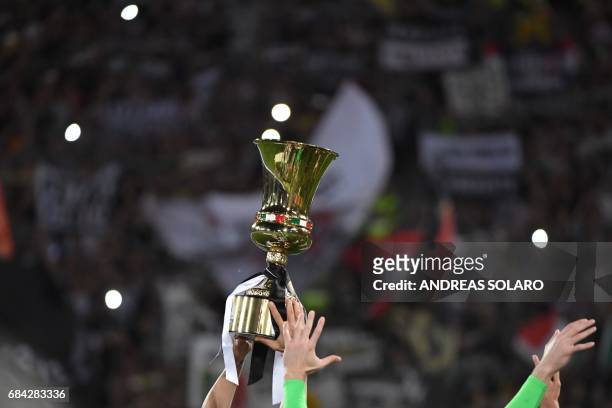 Juventus players hold the trophy after winning the Italian Tim Cup final on May 17, 2017 at the Olympic stadium in Rome. Dani Alves and Leonardo...