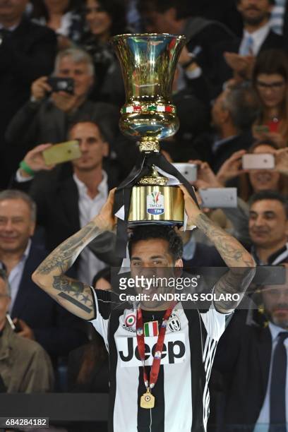 Juventus Defender from Brazil Dani Alves holds the trophy after winning the Italian Tim Cup final on May 17, 2017 at the Olympic stadium in Rome....