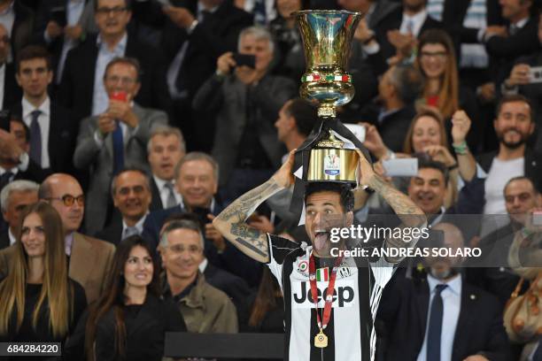 Juventus Defender from Brazil Dani Alves holds the trophy after winning the Italian Tim Cup final on May 17, 2017 at the Olympic stadium in Rome....