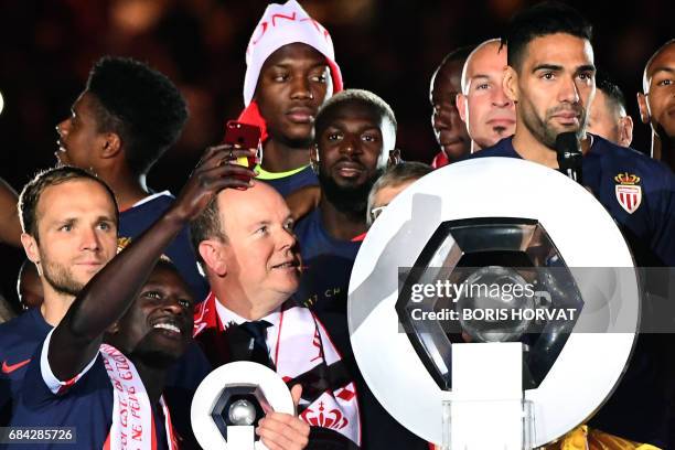 Prince Albert II of Monaco is surrounded by Monaco players at the end of their last French L1 football match Monaco vs St Etienne on May 17, 2017 at...