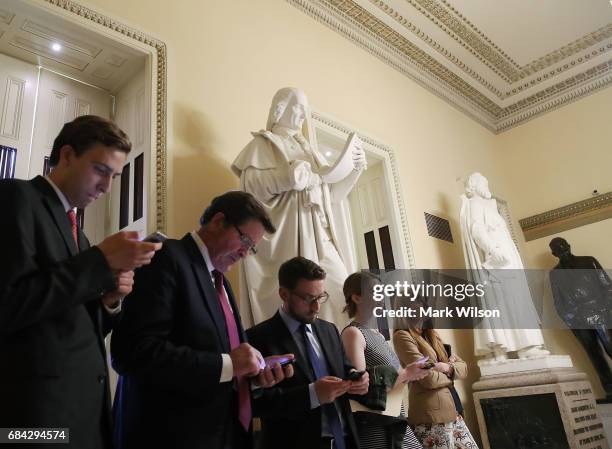 People look at their devices as news comes in that the Justice Department announced that former FBI director Robert Mueller will be a special counsel...
