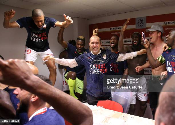 Coach of Monaco Leonardo Jardim is surprised and showered with champagne by his players during his press conference after winning the French League 1...