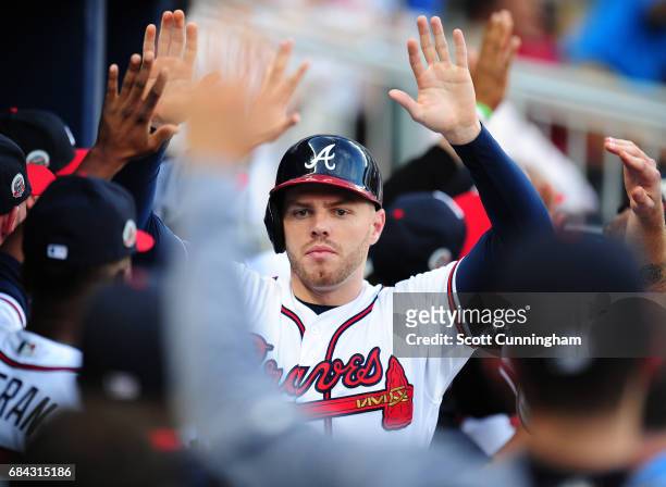 Freddie Freeman of the Atlanta Braves is congratulated by teammates after scoring a first inning run against the Toronto Blue Jays at SunTrust Park...