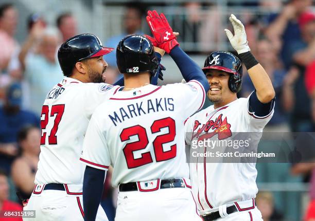Kurt Suzuki of the Atlanta Braves is congratulated by Matt Kemp and Nick Markakis after hitting a first inning three-run home run against the Toronto...