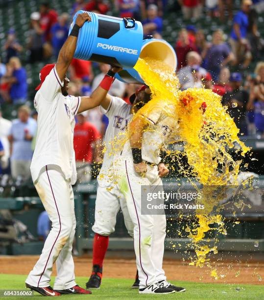 Elvis Andrus of the Texas Rangers and Rougned Odor celebrate Jared Hoying first major league home run with dumping the coolers on him at the end of...
