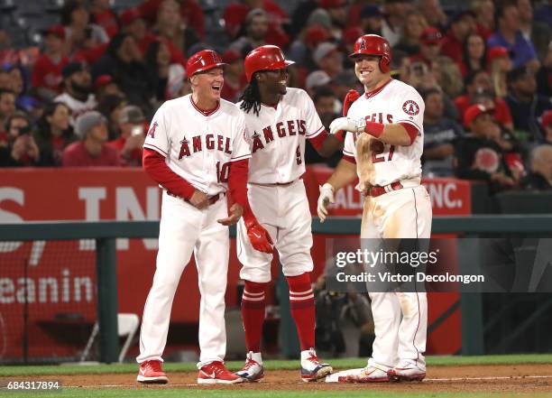 Third base coach Ron Roenicke, Cameron Maybin and Mike Trout of the Los Angeles Angels of Anaheim share a laugh during a pitching change in the...