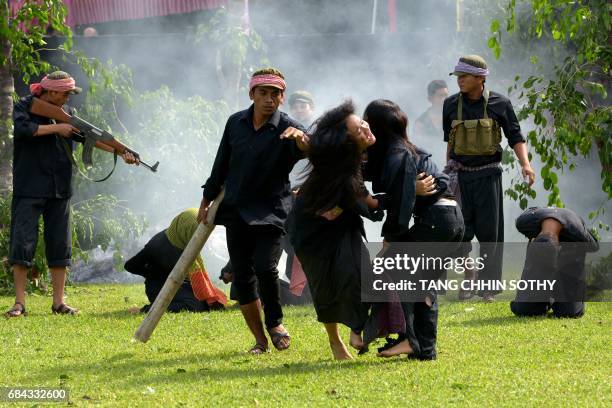 Cambodian fine arts school students take part in a performance to mark the annual 'Day of Anger' at the Choeung Ek killing fields memorial in Phnom...