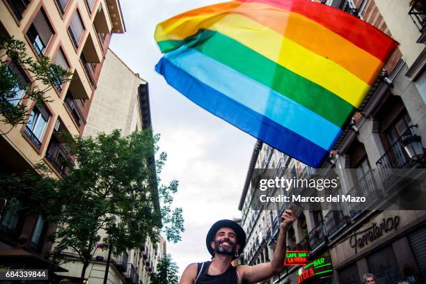 Man waving the rainbow flag during a demonstration for the International Day against Homophobia, Transphobia and Biphobia.