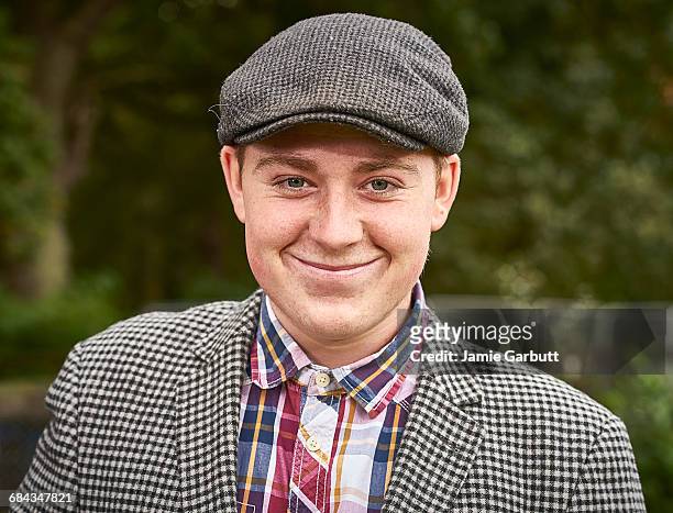 close up portrait of young british farmer smiling - gorra plana fotografías e imágenes de stock