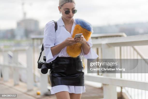 Guest wearing a white blouse and a black mini skirt over it outside Ten Pieces at day 5 during Mercedes-Benz Fashion Week Resort 18 Collections at...