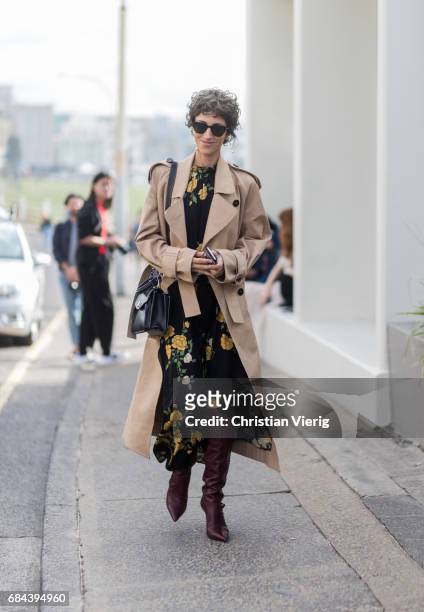 Yasmine Sewell wearing a trench coat, dress with floral print outside Ten Pieces at day 5 during Mercedes-Benz Fashion Week Resort 18 Collections at...