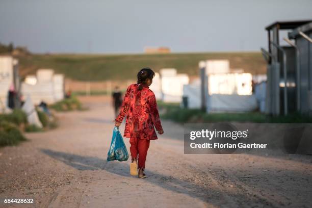 Hasansham, Iraq A girl runs with a plastic bag filled with food through the refugee camp 'Hasansham U3' near Hasansham on April 20, 2017 in...