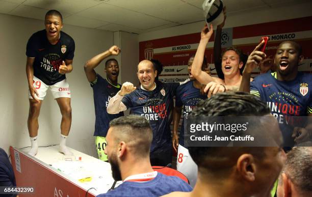 Coach of Monaco Leonardo Jardim is surprised and showered with champagne by his players during his press conference after winning the French League 1...