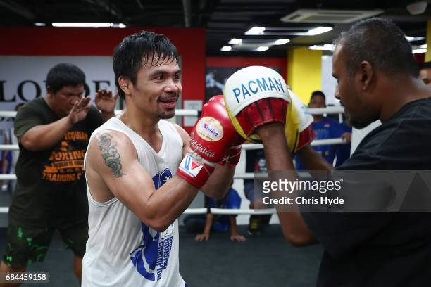 Manny Pacquiao hits the pads with Australian journalist Jamie Pandaram during a training session at the Elorde boxing Gym on May 19, 2017 in Manila,...
