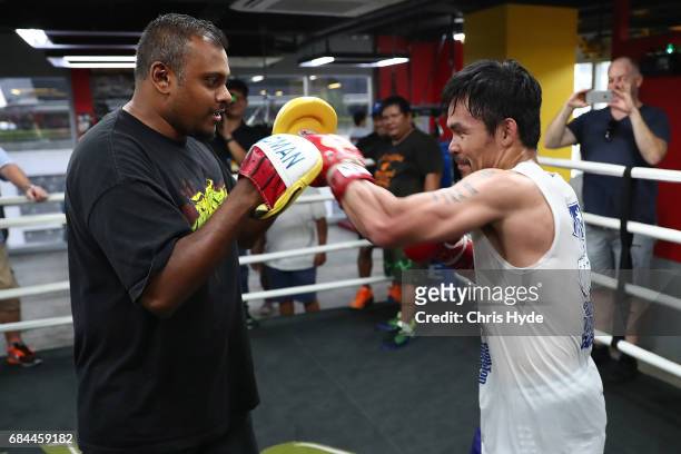 Manny Pacquiao hits the pads with Australian journalist Jamie Pandaram during a training session at the Elorde boxing Gym on May 19, 2017 in Manila,...