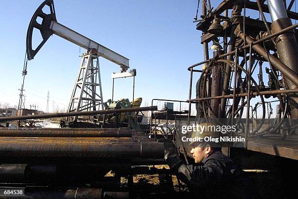 Workers repair an oil well owned by the Yukos company April 24, 2002 in Nefteyugansk, Siberia. Yukos is a fully integrated oil-and-gas company...
