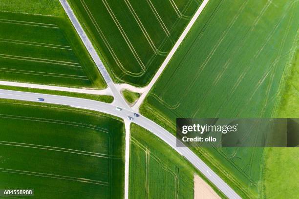 landwirtschaftliche nutzfläche und durchgangsstraße - luftbild - crossroad top view stock-fotos und bilder