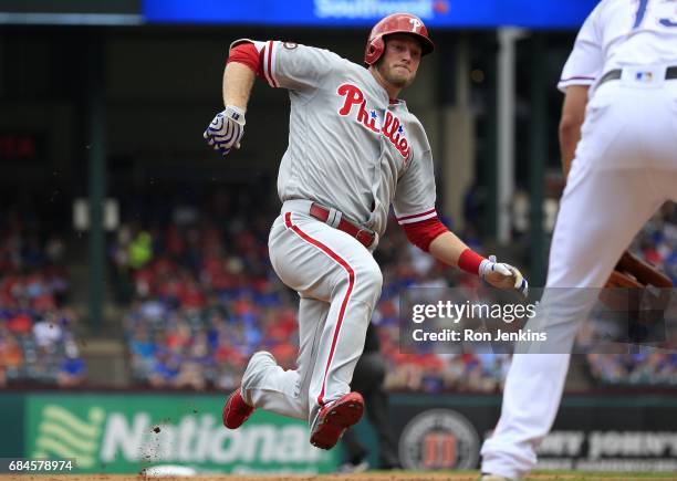 Michael Saunders of the Philadelphia Phillies begins his slide into third base after hitting a triple against the Texas Rangers during the second...
