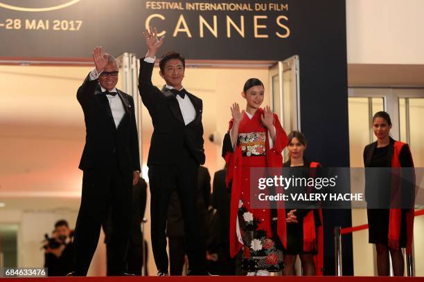 Japanese director Takashi Miike, Japanese actor Takuya Kimura and Japanese actress Hanna Sugisaki wave on May 18, 2017 as they arrive for the...