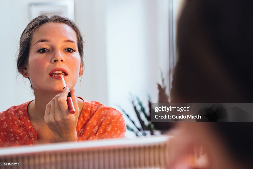 Woman applying lipstick.