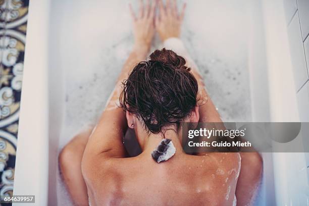 woman using healing stone. - woman bath tub wet hair stock pictures, royalty-free photos & images