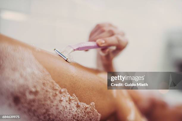 woman shaving her legs. - shaving foto e immagini stock