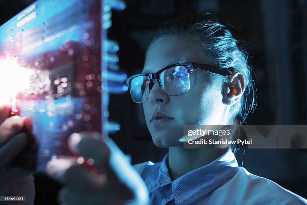 Woman looking at integrated circuit