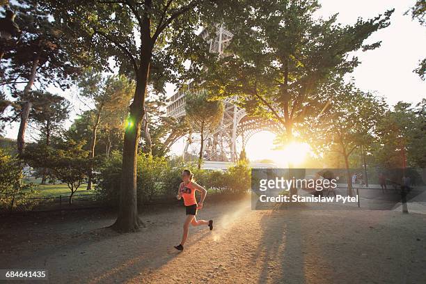 woman running at sunset in paris - paris sport stock pictures, royalty-free photos & images