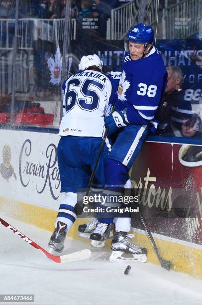 Slater Koekkoek of the Syracuse Crunch throws a hit on Colin Greening of the Toronto Marlies during game 6 action in the Division Final of the Calder...