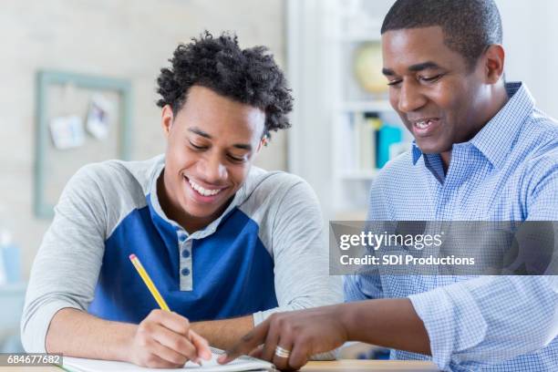 african american father helps son with homework - dad advice stock pictures, royalty-free photos & images