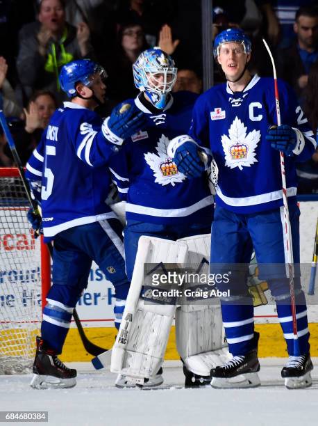 Kasimir Kaskisuo, Andrew Campbell and Steven Oleksy of the Toronto Marlies celebrate their victory over the Syracuse Crunch during game 6 action in...