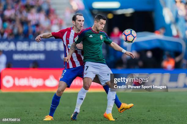 Sergio Leon of Osasuna fights for the ball with Diego Roberto Godin Leal of Atletico de Madrid during the La Liga match between Atletico de Madrid vs...