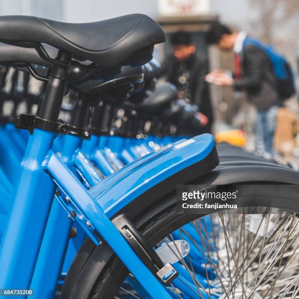 public rental bicycles in a line - bicycle parking station stock pictures, royalty-free photos & images