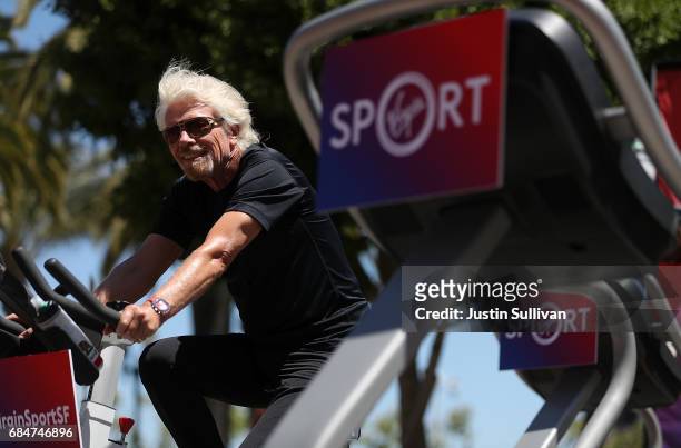 Sir Richard Branson rides an exercise bike during a news conference to announce the launch of Virgin Sport on May 18, 2017 in San Francisco,...