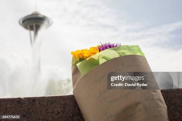 Flowers bearing a message in memory of Chris Cornell rest in front of a fountain in Seattle Center near the Space Needle on May 18, 2017 in Seattle,...