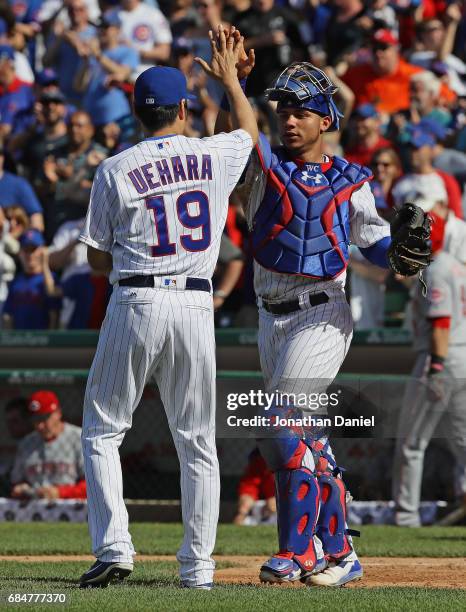 Koji Uehara and Willson Contreras of the Chicago Cubs celebrate a win against the Cincinnati Reds in the 9th inning at Wrigley Field on May 18, 2017...