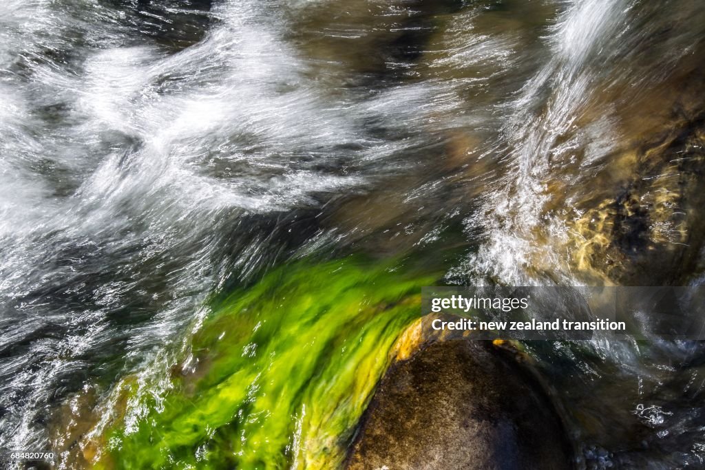 Abstract landscape of slow motion silky water flow and mossy rock