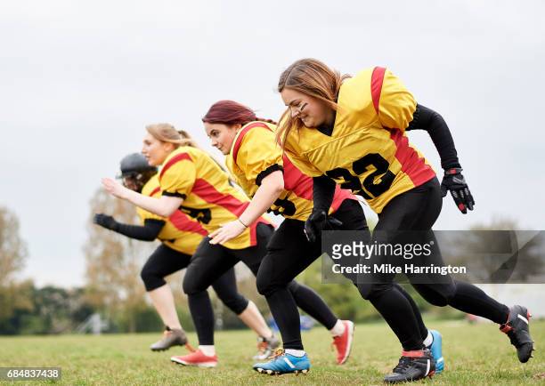 female american football team running together - rush american football stockfoto's en -beelden