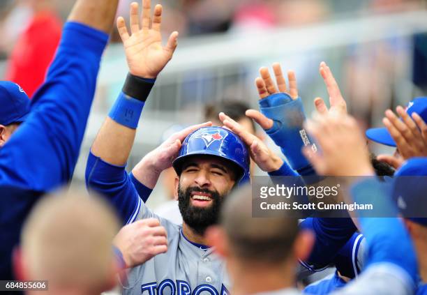 Jose Bautista of the Toronto Blue Jays is congratulated by teammates after scoring a first inning run against the Atlanta Braves at SunTrust Park on...