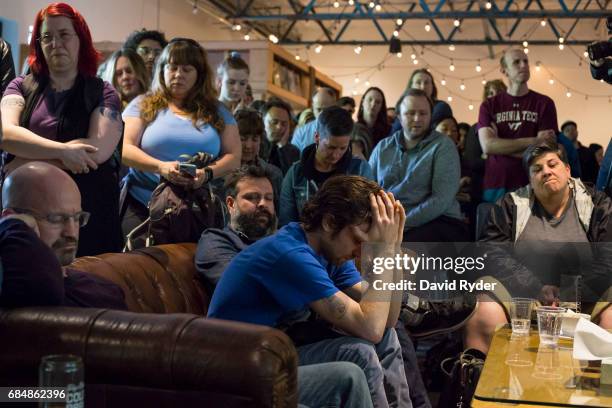 People observe a moment of silence during a memorial for musician Chris Cornell at the KEXP radio studio on May 18, 2017 in Seattle, Washington....