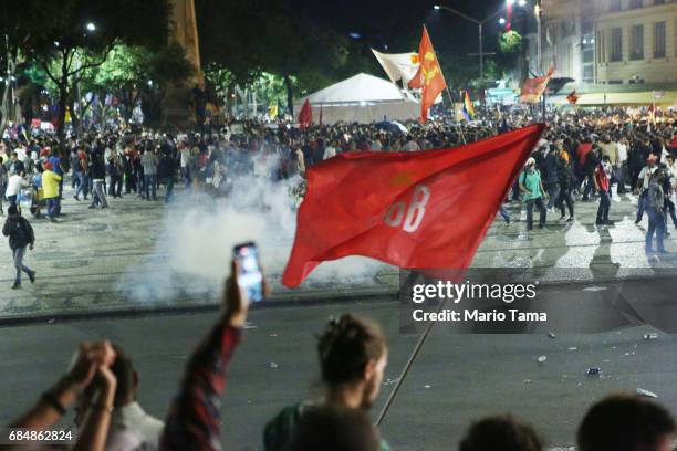 Demonstrators gather during an anti-Temer protest as tear gas is launched on May 18, 2017 in Rio de Janeiro, Brazil. Thousands of protestors hit the...