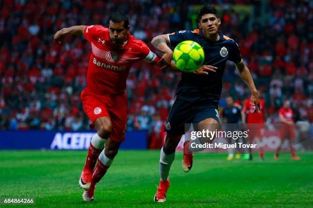 Paulo Da Silva of Toluca fights for the ball with Alan Pulido of Chivas during the semifinals first leg match between Toluca and Chivas as part of...