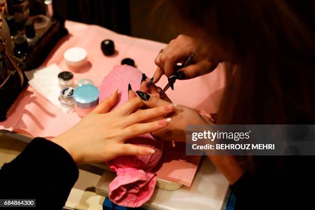 In this picture taken on January 7, 2017 a Japanese woman gets a manicure at a nail saloon in Tokyo. Nail art is taking off in the US and is already...