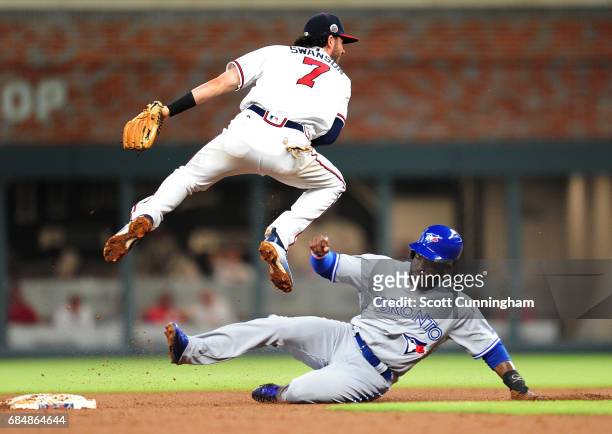 Dansby Swanson of the Atlanta Braves turns a fourth inning double play against Dwight Smith, Jr. #15 of the Toronto Blue Jays at SunTrust Park on May...