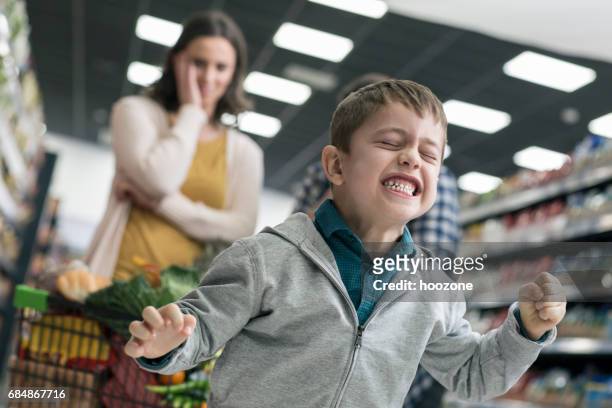 slechte jongen in supermarkt - different emotions children stockfoto's en -beelden