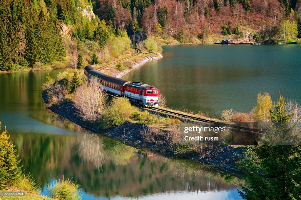 Train passing through lake near Mlynky village in the Slovak Paradise (Slovensky raj) national park, Slovakia.
