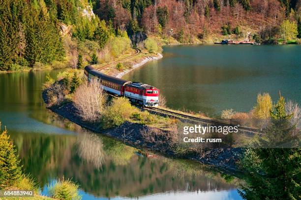train passing through lake near mlynky village in the slovak paradise (slovensky raj) national park, slovakia. - slovakia stock pictures, royalty-free photos & images