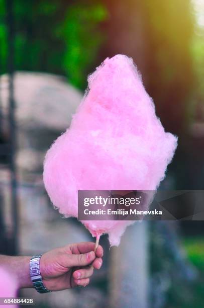 hand holding pink cotton candy - cotton candy stock-fotos und bilder