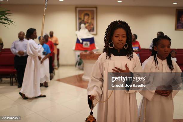 People take part in the entrance procession during a service at the Notre Dame D'Haiti Catholic Church as they celebrate Haitian Flag day in the...
