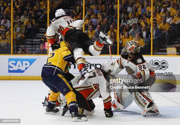 Josh Manson of the Anaheim Ducks falls over Mike Fisher of the Nashville Predators and Hampus Lindholm of the Anaheim Ducks during the third period...